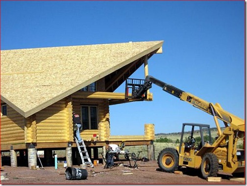 The boom truck is holding up the beam the beams to allow for the placement of the log column, and the settling jacks.  With the Finnish system, we can see up to 1” of settling for an 8’-0” tall wall.  If this isn’t accommodated for, the differential settling of the walls, versus the columns will create a whole world of issues. 